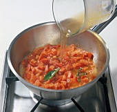 Liquid being added to pepper mixture in saucepan, step 2
