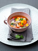 Chicken soup with vegetables and herbs in bowl