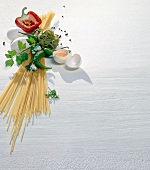 Noodles, eggs, halved red pepper, chillies and spice on white background