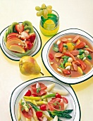 Varieties of dishes with fruit salad, grape juice, sausage stew and asparagus salad