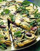 Close-up of zucchini and spinach omelette with black olives on plate