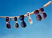 Variety of sunglasses hanging on wood