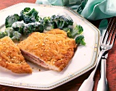 Fried cordon bleu with broccoli and sauce on plate