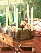 Wicker fruit basket with apple, roses and candle holder