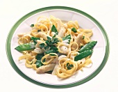 Pasta garnished with sweet peas and asparagus on plate