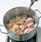 Pieces of rabbit meat being fried in casserole, step 2