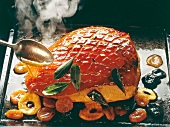 Golden brown roasted pork with fruits on plate
