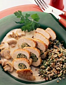 Stuffed boneless chicken breast with sauce, mushrooms and mixture of rice grain on plate