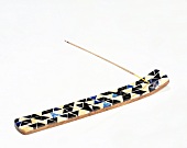 Close-up of long colourful incense holder on white background