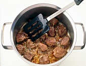 Frying meat in pot on white background