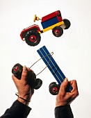 Man destroying a toy car angrily with his hands