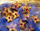 Close-up of konigsberg marzipan star biscuits with cherry and pistachios on top