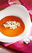 Tomato and carrot soup garnished with ginger and barley in bowl