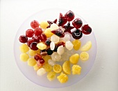 Colourful fruit juice ice cubes on white background