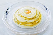 Close-up of egg yolk on parmesan foam on plate