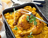 Braised chicken legs with corn and potatoes in baking dish