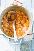 Apricot jam with cinnamon in pot, overhead view