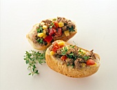 Peppers, tuna and olives on slices of bread on white background