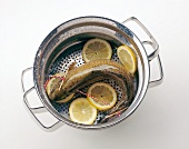 Fish steamed with lemon slices in steamer