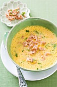 Curry-Kürbissuppe mit Krabben in Teller, gelb, grün