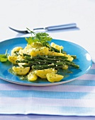Beans and potato salad with parsley basil pesto on blue plate