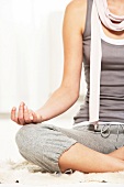 Close-up of woman performing yoga in lotus position