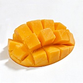Halved mango cut into cubes on white background