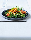 Salad of sweet potatoes, tomatoes, arugula and avocado on plate