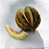 Yellow and green cantaloupe on white surface