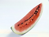Slice of watermelon with seeds on white background