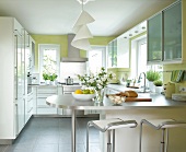 Modern kitchen in white with metallic bar and bar stools