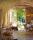 Gewölbe aus Stein und offene Tür zum Garten, "Villa Saint-Louis"