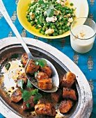 Indien - Paneer mit Erbsen und Indische "Currywurst" auf Tellern