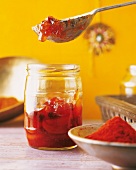 Indien - Chutney im Glas, rot, Hintergrund gelb, unscharf