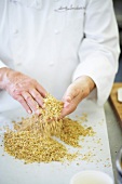 Chef mixing biscuit, oil and walnuts