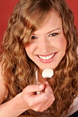 Close-up of woman having desert with spoon, smiling