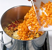 Diced pumpkin with vegetables being cooked in casserole