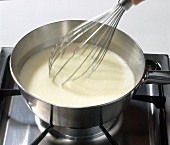 Liquid dough being whisked in pot for cake