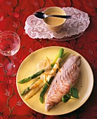 Dorade in salt crust with orange sauce and asparagus on plate, Spain
