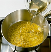 Close-up of white wine being poured in passion fruit pulp