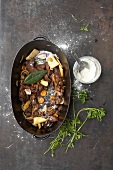 Roasted bones with various vegetables in roasting pan