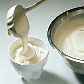 Cream being poured in ramekin for preparation of desserts