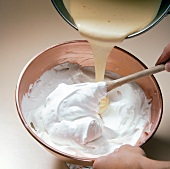 Pouring egg yolk in mixture for preparation of biscuits, step 5