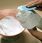 Close-up of hand filling meringue in icing bag, step 6