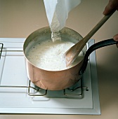 Ingredients being added for boiling while preparing choux pastry, step 1