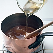 Syrup being poured in apricot glaze for preparation of dessert, step 1