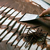 Close-up of hand removing chocolate curls with spatula