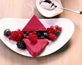 Berry fruit jelly triangles with raspberries and blackberries on plate