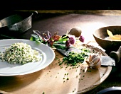 Herb rice on plate beside garlic bulb and mezzaluna