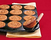 Muffins, Ahorn-Zimt-Muffins in Muffinblech, braun, Hintergrund rot
